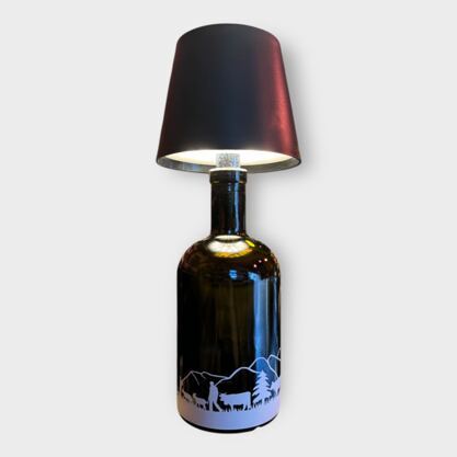 Glasflasche mit Lampe Silhouette Alpabzug Gebirge